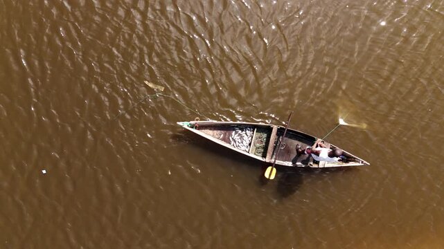 Aerial top view of a traditional fisherman in a wooden boat with his catch in Luanda, Angola