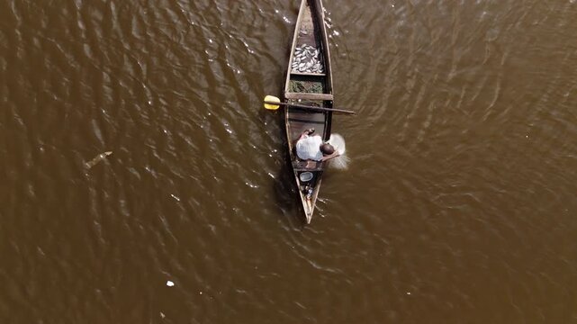 Aerial top view of a traditional fisherman in a wooden boat with his catch in Luanda, Angola