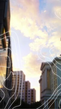 Vertical video: Cam tilting upward, revealing city gap golden sky, white contours rising for design