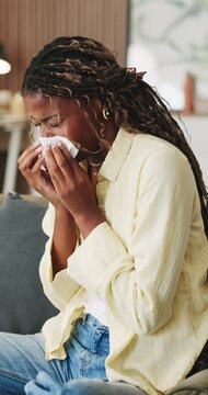 Woman, sneeze or blowing nose in apartment with tissue, health problem or flu symptoms from burnout. Sick, black person and allergy in home with toilet paper, virus or congestion from sinus infection