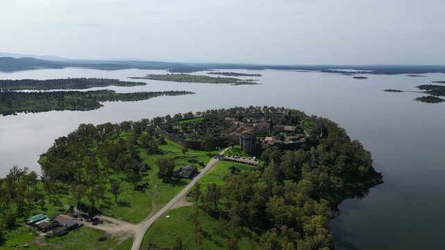Aerial drone view of Granadilla village on an island surrounded by a reservoir in Extremadura, Spain. Scenic landscape with water and natural surroundings.