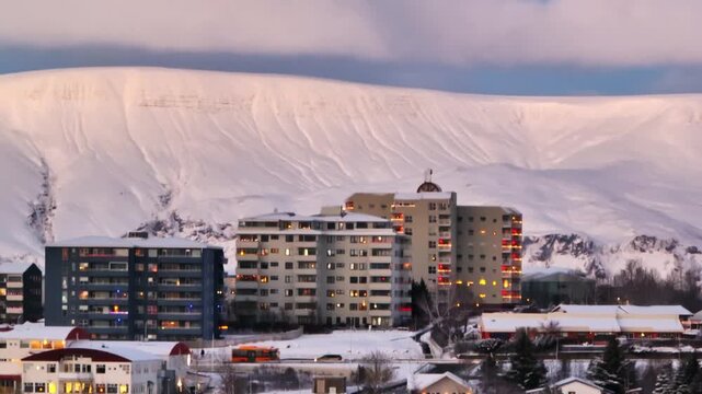 Reykjavik apartment buildings at dusk with Mount Esja covered in snow behind the city, creating a calm Iceland winter urban scene.