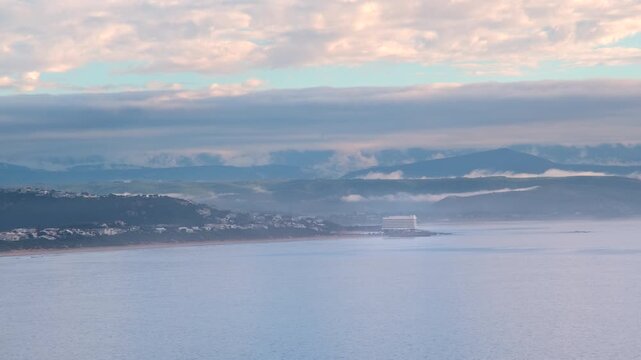 Long view over ocean from Robberg toward Beacon Island hotel and misty mountains