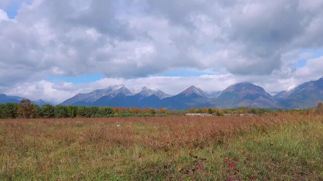 The autumn landscape of Arshan showcases vibrant foliage colors against the backdrop of the majestic Eastern Sayan Mountains. Concept: tourism, outdoor recreation.