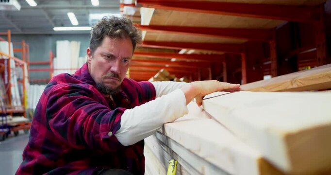 Man Selecting Lumber in a Warehouse Store