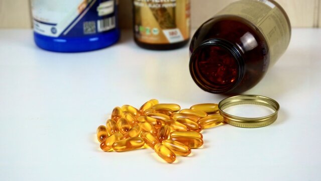 Omega-3 fish oil capsules spilling from supplement bottle