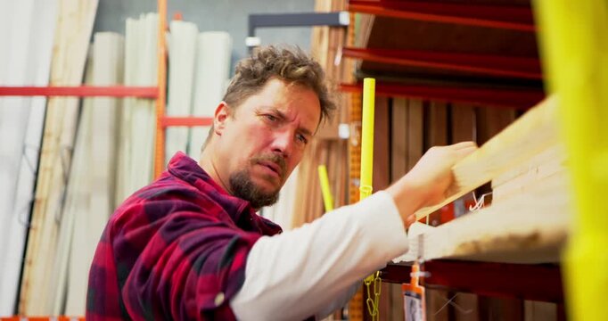 Man Selecting Lumber in a Warehouse Store