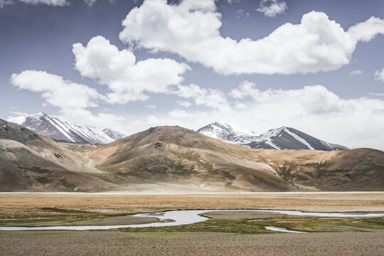 Mountain landscape with a view of a rocky mountain ridge with snow and glaciers in the highlands of Tajikistan in the Pamirs. A panorama of the Tien Shan Mountains for background