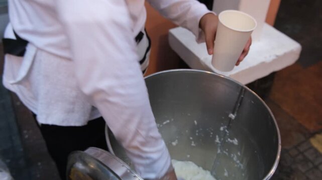 Street vendor preparing taho, Philippine snack food made of fresh soft/silken tofu, brown sugar and sago.