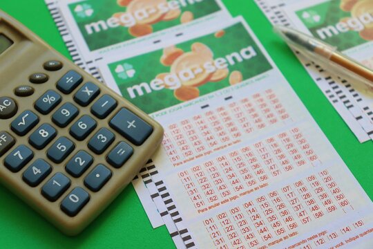 Salvador, Brazil - April 18, 2026: Mega Sena lottery tickets on a green background. Loterias Caixa do Brasil (Brazilian national lottery). Mega-sena logo. 