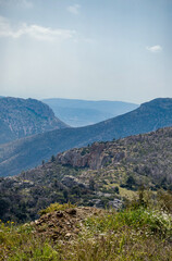Obraz premium View from the top of mountain to mountain peaks and hills at Boeotia-Greece. Vertical photo, blue sky at the background.