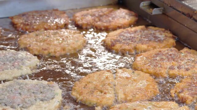 Seoul, South Korea - Apr. 18, 2026 : Traditional Korean mung bean pancakes, Bindaetteok, sizzling on a large griddle at Gwangjang Market, Seoul. 