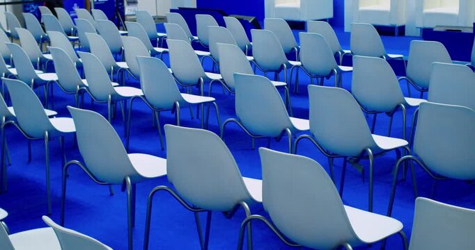 Empty modern conference hall with chairs arranged in a spacious bright room.