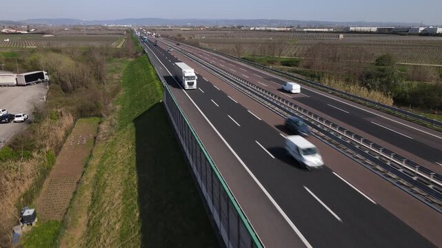Aerial drone footage featuring a smooth forward tracking shot in reverse motion over the A4 motorway near Verona, Italy.