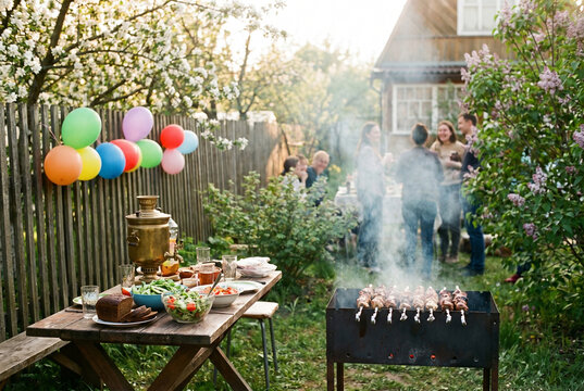 Outdoor barbecue party with friends and colorful balloons in garden