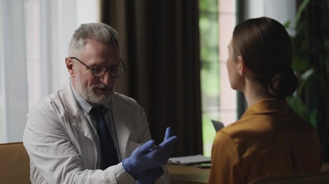 Male ENT doctor examining woman's neck for inflammation signs