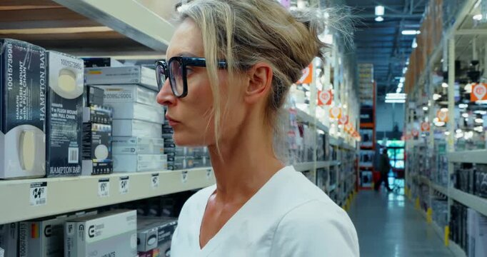 Woman Shopping for Light Fixtures in Hardware Store
