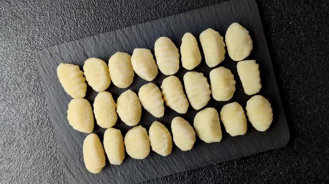 Raw homemade potato gnocchi, made with salt and spices, ready for lunch. Raw gnocchi as a food background for your design