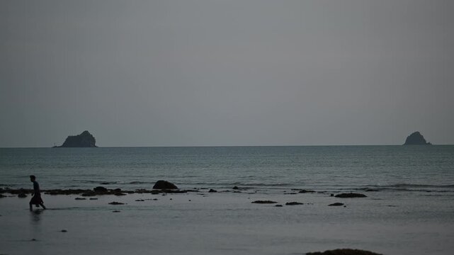 Man walking between offshore islands at Tubkaek Beach