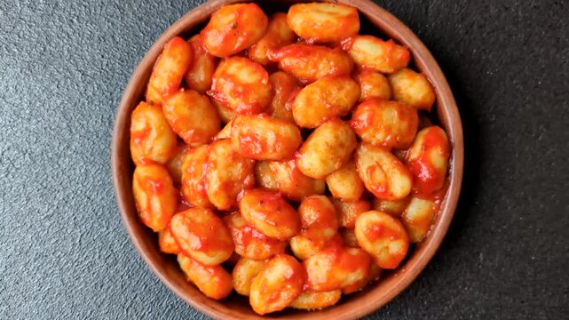 Homemade potato gnocchi with Bolognese sauce, seasoned with salt and spices, ready for lunch. Gnocchi with sauce as a food background for your design