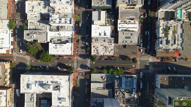 Drone flying north along 5th Street above downtown San Diego at 9AM with a top-down perspective capturing streets, buildings, and morning traffic below.