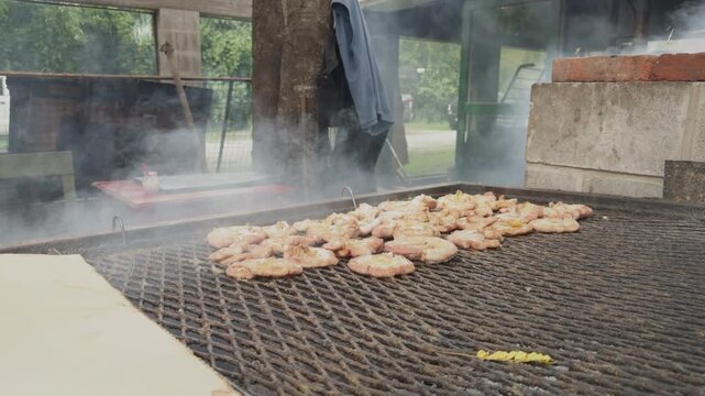Outdoor barbecue with pork chops grilling over coals