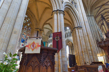 View of a stately cathedral interior, featuring high vaulted ceilings and massive stone columns. A richly carved wooden pulpit in Beverley Minster - Yorkshire - Great Britain © Robert