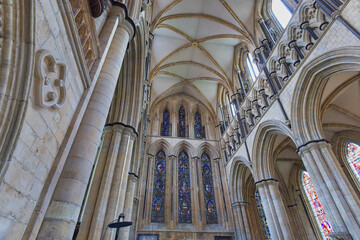 An impressive Gothic cathedral interior showcasing towering columns, vaulted ceilings, and vibrant stained-glass windows in Beverley Minster - Yorkshire - Great Britain © Robert