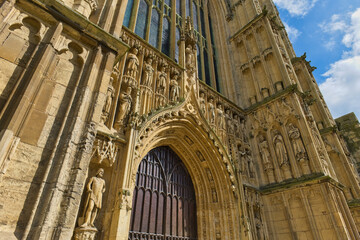 A low-angle view of a grand Gothic cathedral's ornate stone entrance, richly carved with numerous statues in Beverley Minster - Yorkshire - Great Britain © Robert