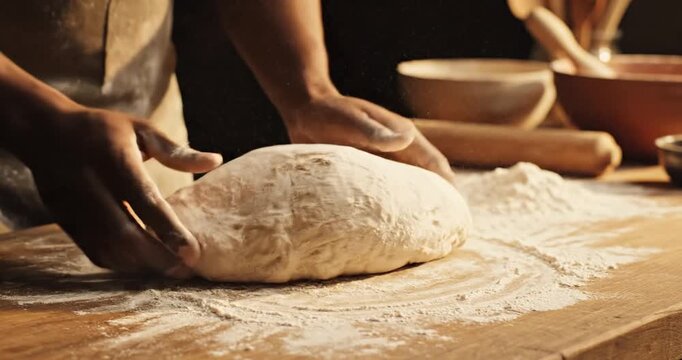 A baker kneading dough on a wooden table surrounded by flour and baking tools in a cozy kitchen