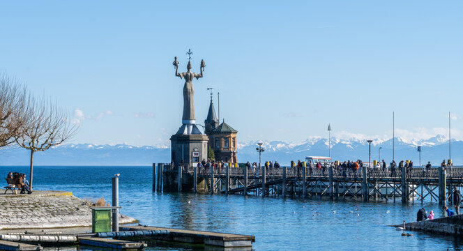 Imperia statue standing at konstanz harbor with alps