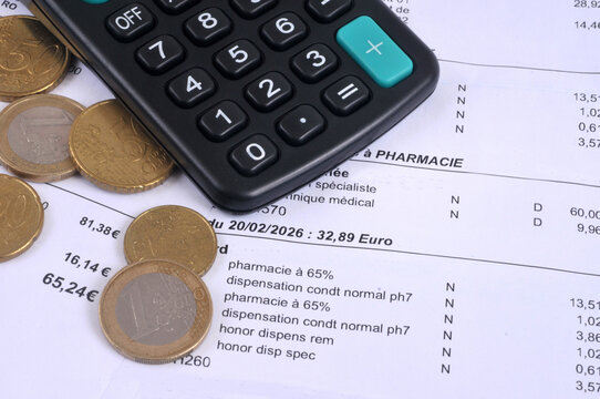 D&eacute;compte de mutuelle sant&eacute; fran&ccedil;ais avec une calculatrice et des pi&egrave;ces de monnaie en euros