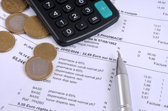 D&eacute;compte de mutuelle sant&eacute; fran&ccedil;ais avec une calculatrice, des pi&egrave;ces de monnaie en euros et un stylo