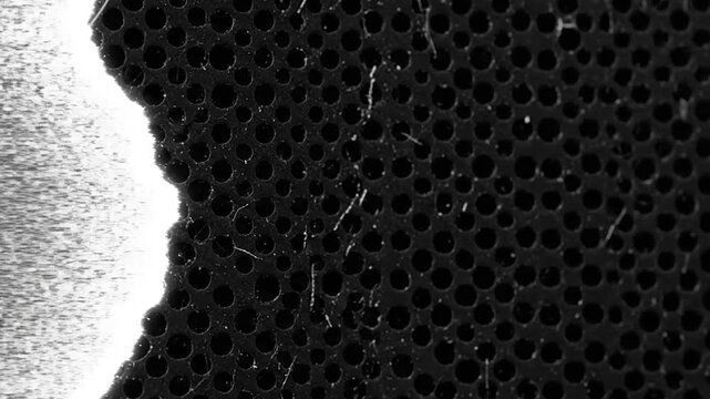 Black perforated mesh texture with white digital glitch distortion