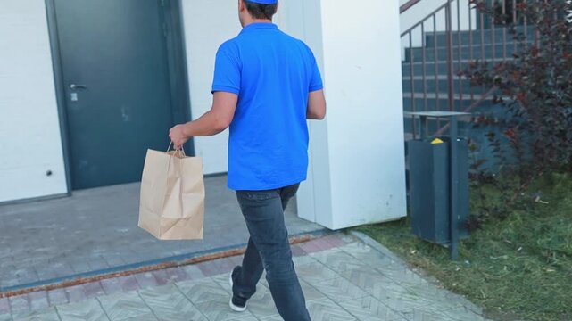 A courier delivers an order with ready-made food and coffee to go to the client s home. home delivery of ready-made food from restaurants and cafes, courier service