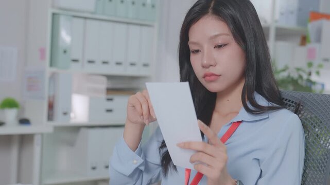 ฺBeautiful Asian accountant calculates financial expenses related to credit, budgets credit costs, records expenses or bills, reviews receipts, and plans tax assessments. Work actively.