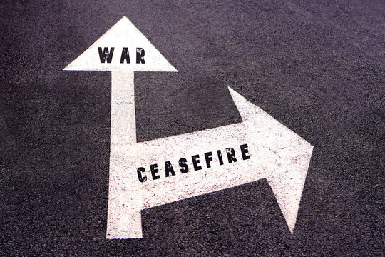 war and ceasefire concepts. road sign on asphalt with two arrows indicating different directions.