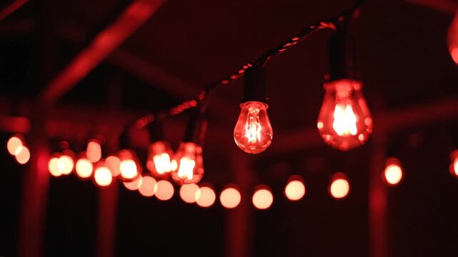 Decorative string lights illuminated in red against a dark backdrop