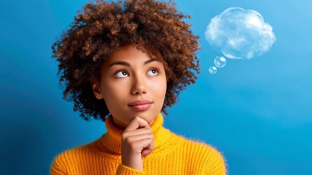 Junge Frau mit Afro-Locken und gelbem Rollkragenpullover blickt nachdenklich nach oben, wei&szlig;e Gedankenwolke &uuml;ber ihrem Kopf. Blauer Hintergrund betont den inneren Denkprozess