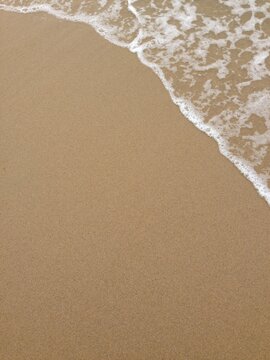 Gentle Ocean Wave Washing Onto Sandy Beach