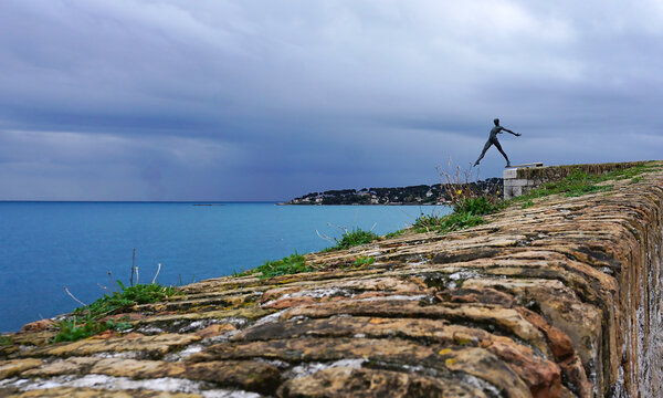 Antibes, France - March 10, 2026: Sculpture named Le Defi or The Challenge in the walls in the old town. The art by Nicolas Lavarenne is aligned with the horizon, creating a beautiful visual effect.