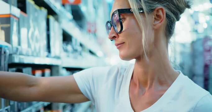 Woman Selecting Products in a Hardware Store Aisle