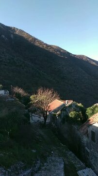 Montenegrin village of Gornji Stoliv, forested slope of Vrmac, and expansive view of the Bay of Kotor. Depicts cinematic reveal of hidden Adriatic landscapes and the beauty of slow travel discovery.