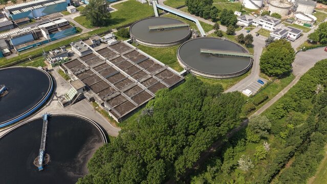 Wastewater Treatment Plant Aerial View: An expansive aerial perspective showcases a functional wastewater treatment plant, with its intricate network of tanks, channels.