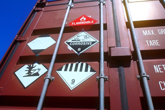 Flammable and corrosive hazmat stickers on container door.