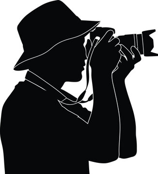 Silhouette of a person using an old-fashioned camera with a wide-brimmed hat