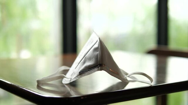 Close-up of N95 face mask on a laptop and smartphone for PM 2.5 dust protection, healthcare, and urban lifestyle concept