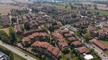 Obraz premium Aerial View of a Suburban Neighborhood: An expansive aerial perspective showcases a vibrant suburban neighborhood with tightly packed residential buildings featuring terracotta roofs.