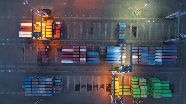 Colorful stacked cargo containers forming geometric industrial pattern from above