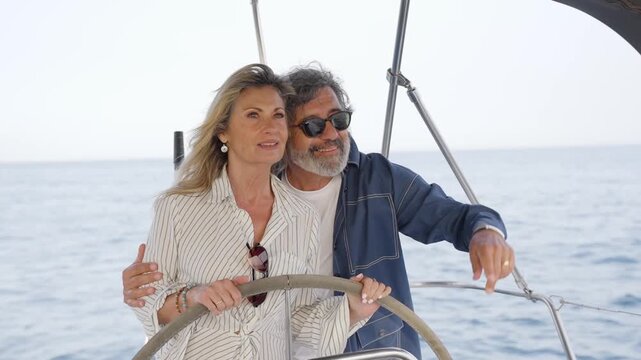 Mature couple enjoying a romantic boat trip sailing the sea